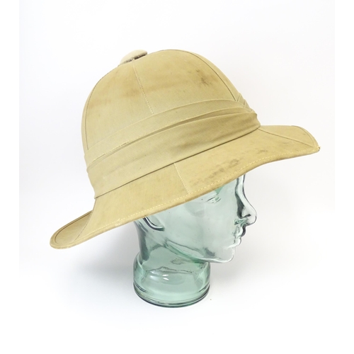 800 - Militaria : an early 20thC pith helmet by Linney, London, with khaki drill cotton exterior, the inte... 