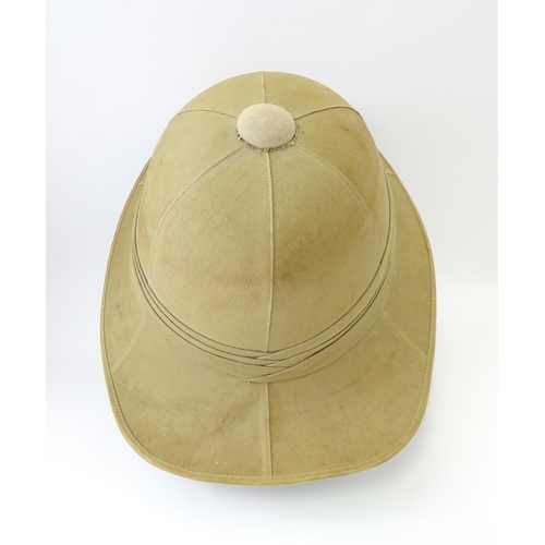 800 - Militaria : an early 20thC pith helmet by Linney, London, with khaki drill cotton exterior, the inte... 