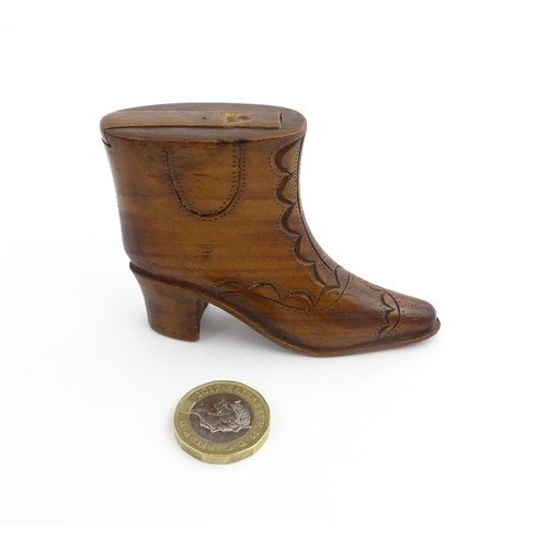 1200 - Treen : A 19thC novelty shoe snuff box of heeled boot form with carved decoration, the sliding lid o... 