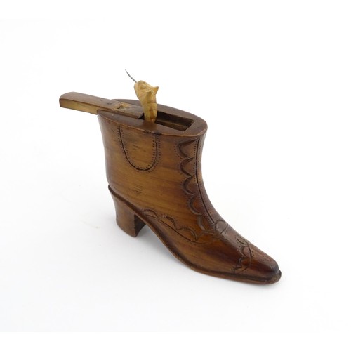 1200 - Treen : A 19thC novelty shoe snuff box of heeled boot form with carved decoration, the sliding lid o... 