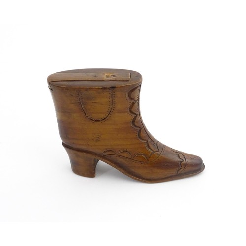 1200 - Treen : A 19thC novelty shoe snuff box of heeled boot form with carved decoration, the sliding lid o... 