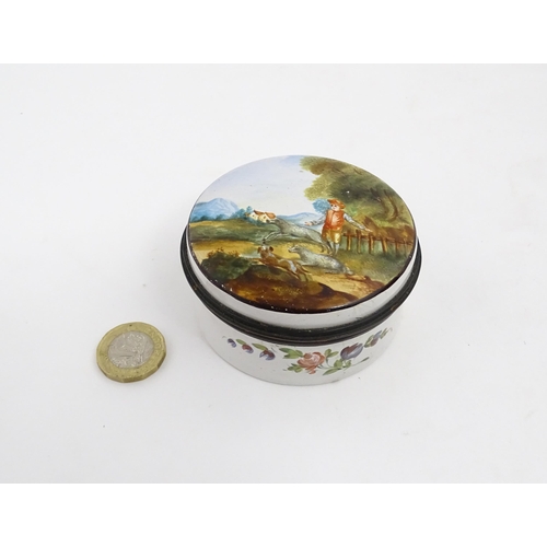 1284 - A 19thC enamel box of circular form with hand painted decoration depicting a country landscape with ... 