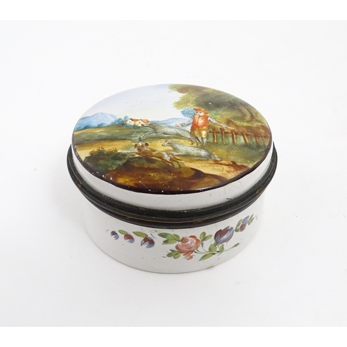 1284 - A 19thC enamel box of circular form with hand painted decoration depicting a country landscape with ... 