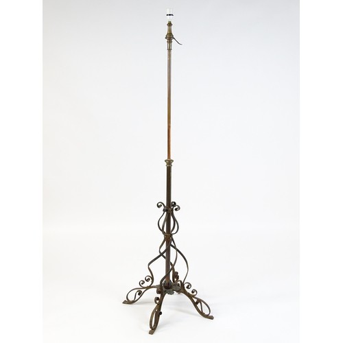 1553 - A c.1900 wrought iron standard lamp raised on four feet and decorated with wrought iron tendrils. Ma... 