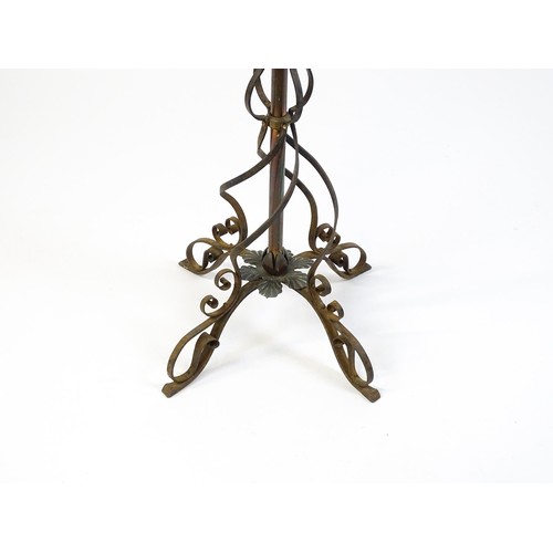 1553 - A c.1900 wrought iron standard lamp raised on four feet and decorated with wrought iron tendrils. Ma... 