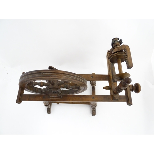 1301 - Treen : A Victorian turned wooden wool spinning wheel with a central six spoke wheel, and a foot ped... 