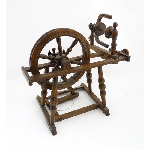 1301 - Treen : A Victorian turned wooden wool spinning wheel with a central six spoke wheel, and a foot ped... 