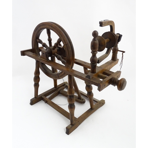 1301 - Treen : A Victorian turned wooden wool spinning wheel with a central six spoke wheel, and a foot ped... 