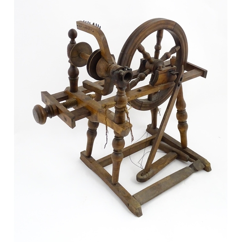 1301 - Treen : A Victorian turned wooden wool spinning wheel with a central six spoke wheel, and a foot ped... 