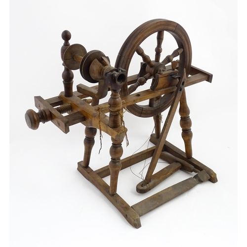 1301 - Treen : A Victorian turned wooden wool spinning wheel with a central six spoke wheel, and a foot ped... 