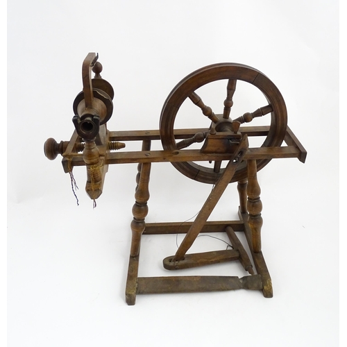 1301 - Treen : A Victorian turned wooden wool spinning wheel with a central six spoke wheel, and a foot ped... 