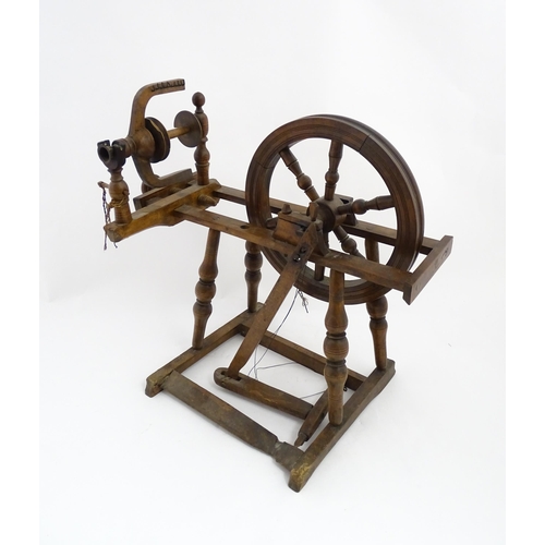 1301 - Treen : A Victorian turned wooden wool spinning wheel with a central six spoke wheel, and a foot ped... 