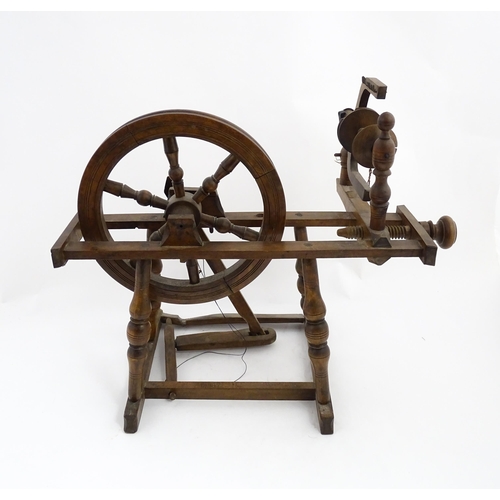 1301 - Treen : A Victorian turned wooden wool spinning wheel with a central six spoke wheel, and a foot ped... 