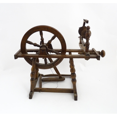 1301 - Treen : A Victorian turned wooden wool spinning wheel with a central six spoke wheel, and a foot ped... 