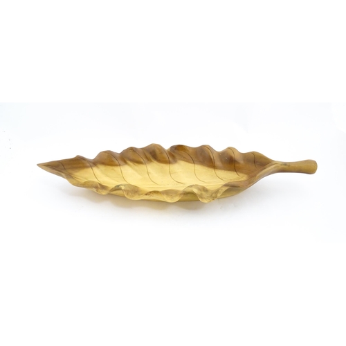 1311 - A 20thC carved wooden dish modelled as a stylised leaf. Approx. 30