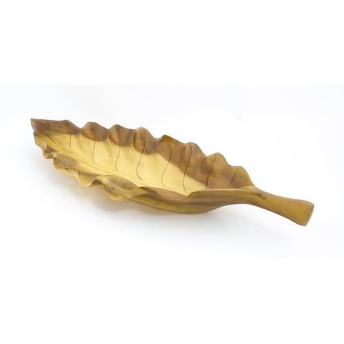 1311 - A 20thC carved wooden dish modelled as a stylised leaf. Approx. 30