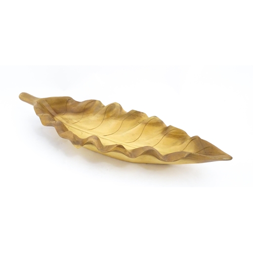 1311 - A 20thC carved wooden dish modelled as a stylised leaf. Approx. 30