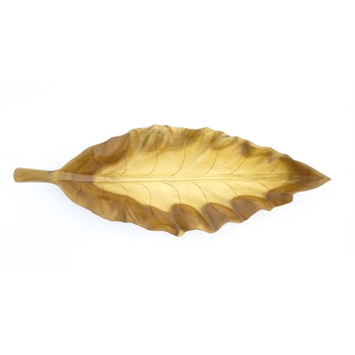 1311 - A 20thC carved wooden dish modelled as a stylised leaf. Approx. 30