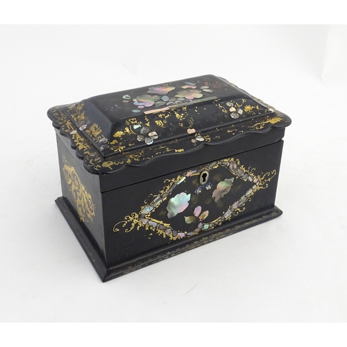 1328 - A Victorian lacquered papier mache tea caddy with abalone inlay and gilt scrolling detail. Opening t... 