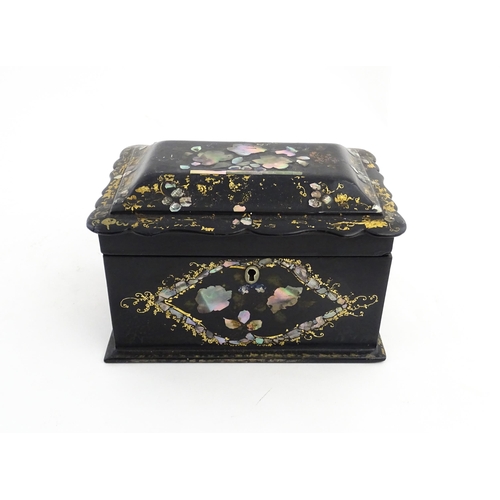 1328 - A Victorian lacquered papier mache tea caddy with abalone inlay and gilt scrolling detail. Opening t... 