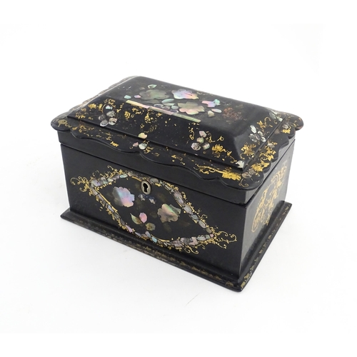 1328 - A Victorian lacquered papier mache tea caddy with abalone inlay and gilt scrolling detail. Opening t... 