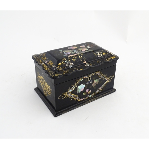 1328 - A Victorian lacquered papier mache tea caddy with abalone inlay and gilt scrolling detail. Opening t... 