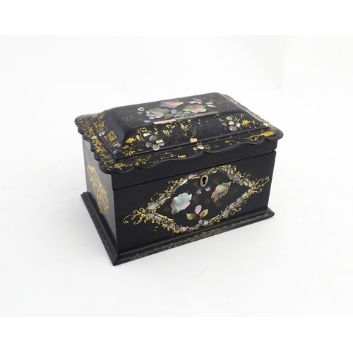 1328 - A Victorian lacquered papier mache tea caddy with abalone inlay and gilt scrolling detail. Opening t... 