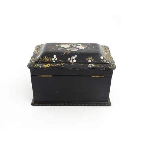 1328 - A Victorian lacquered papier mache tea caddy with abalone inlay and gilt scrolling detail. Opening t... 