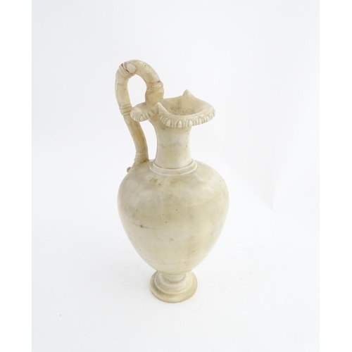 1334 - A carved alabaster ewer / jug in the Romanesque style. Approx. 18 1/2