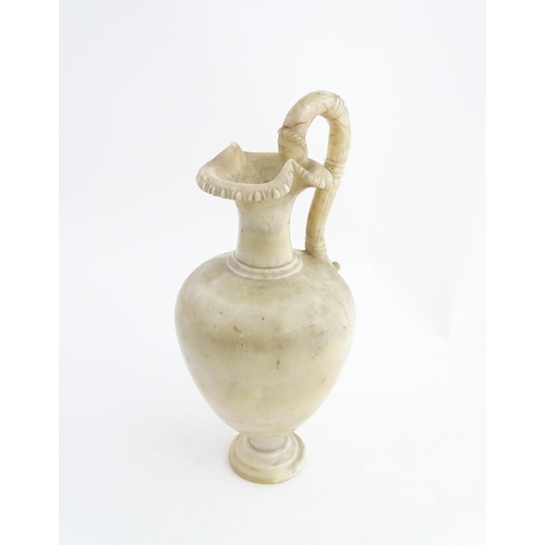 1334 - A carved alabaster ewer / jug in the Romanesque style. Approx. 18 1/2