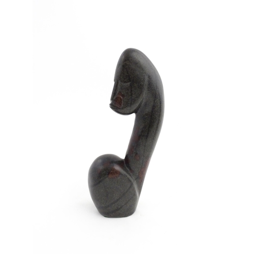 1335 - A Zimbabwean 20thC soapstone carving by Miguel Kennedy depicting a stylised figure. Signed Miguel un... 