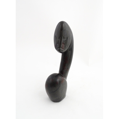 1335 - A Zimbabwean 20thC soapstone carving by Miguel Kennedy depicting a stylised figure. Signed Miguel un... 