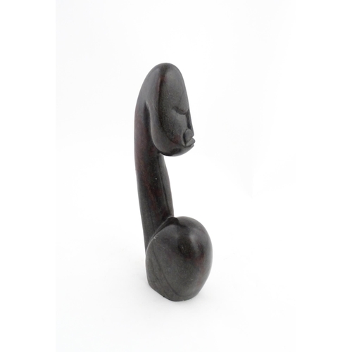 1335 - A Zimbabwean 20thC soapstone carving by Miguel Kennedy depicting a stylised figure. Signed Miguel un... 