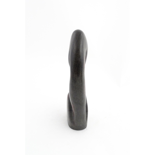 1335 - A Zimbabwean 20thC soapstone carving by Miguel Kennedy depicting a stylised figure. Signed Miguel un... 