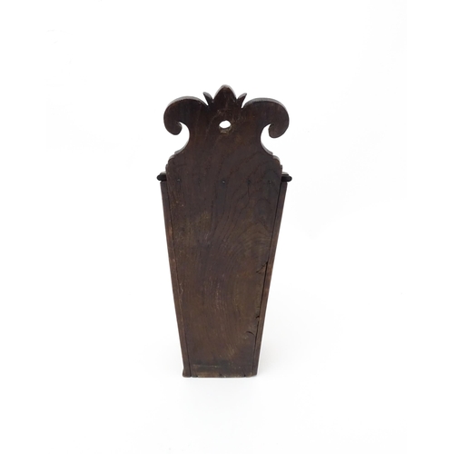 1341 - Treen : An early 19thC oak candle box of tapering form with shaped top, brass studded leather hinge,... 