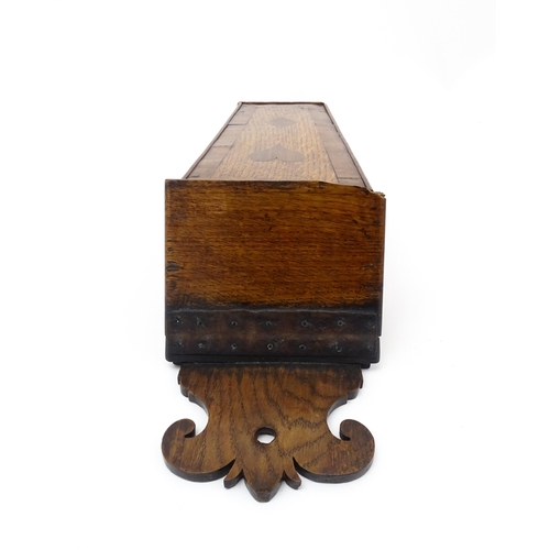 1341 - Treen : An early 19thC oak candle box of tapering form with shaped top, brass studded leather hinge,... 