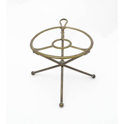 1344 - An early 20thC brass folding trivet with tripod base, stamped 'W T & S' (William Tonks & Sons) with ... 