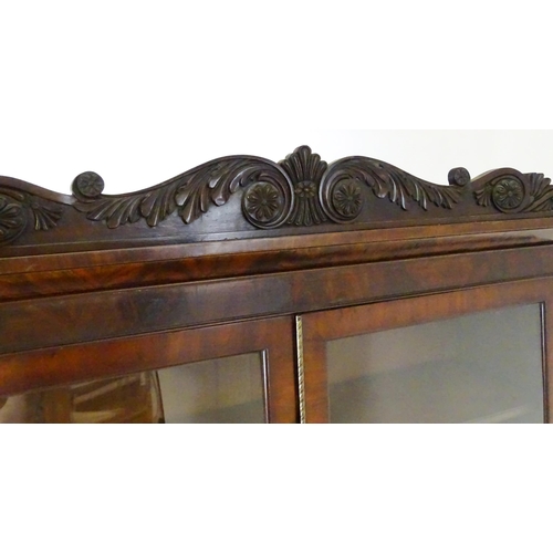 1558 - A late Georgian secretaire bookcase a carved scrolling pediment above two glazed doors. The long sec... 