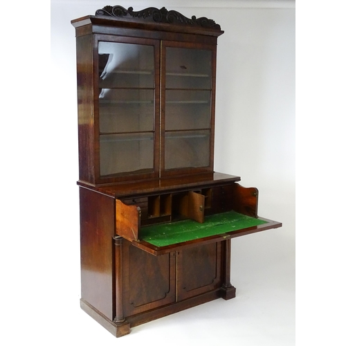 1558 - A late Georgian secretaire bookcase a carved scrolling pediment above two glazed doors. The long sec... 