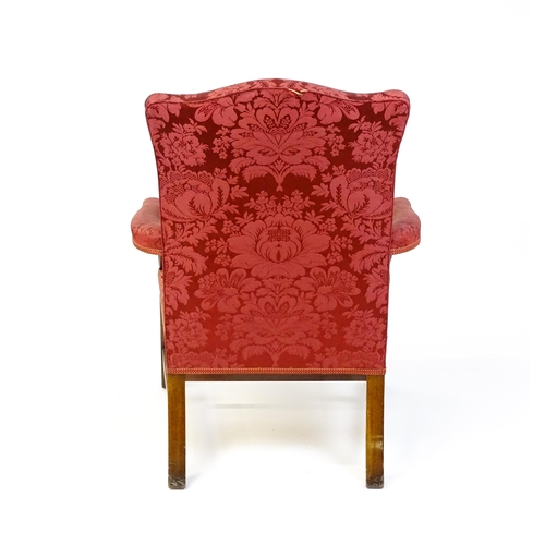 1559 - A 19thC upholstered Gainsborough armchair with carved floral decoration to the arms and raised on ch... 