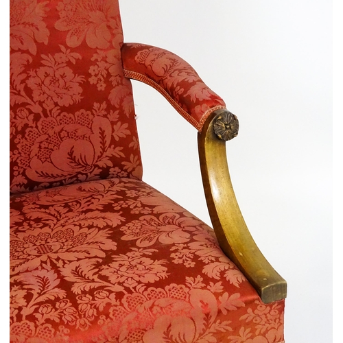 1559 - A 19thC upholstered Gainsborough armchair with carved floral decoration to the arms and raised on ch... 