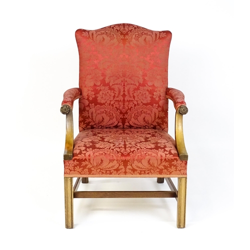 1559 - A 19thC upholstered Gainsborough armchair with carved floral decoration to the arms and raised on ch... 