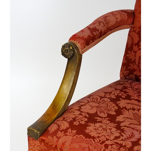 1559 - A 19thC upholstered Gainsborough armchair with carved floral decoration to the arms and raised on ch... 