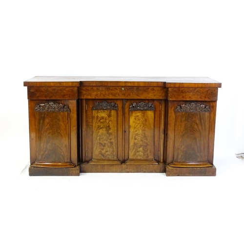 1567 - A Victorian mahogany sideboard with an inverted break front top, three frieze drawers and four panel... 