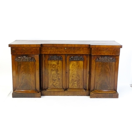 1567 - A Victorian mahogany sideboard with an inverted break front top, three frieze drawers and four panel... 