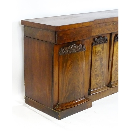 1567 - A Victorian mahogany sideboard with an inverted break front top, three frieze drawers and four panel... 