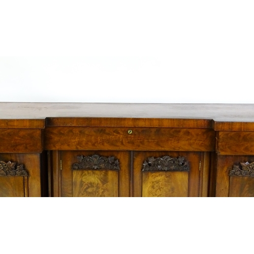 1567 - A Victorian mahogany sideboard with an inverted break front top, three frieze drawers and four panel... 