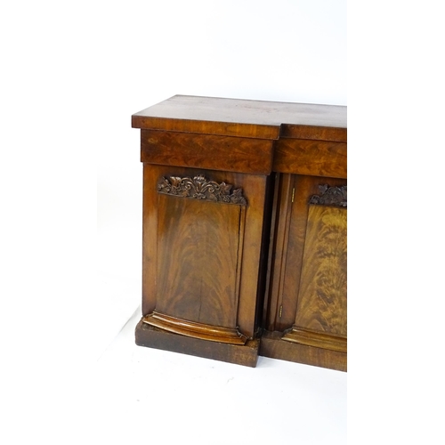 1567 - A Victorian mahogany sideboard with an inverted break front top, three frieze drawers and four panel... 