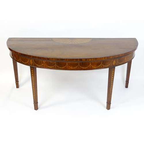 1573 - A large late 18thC mahogany serving table of demi lune form, having a marquetry inlaid top with sunb... 