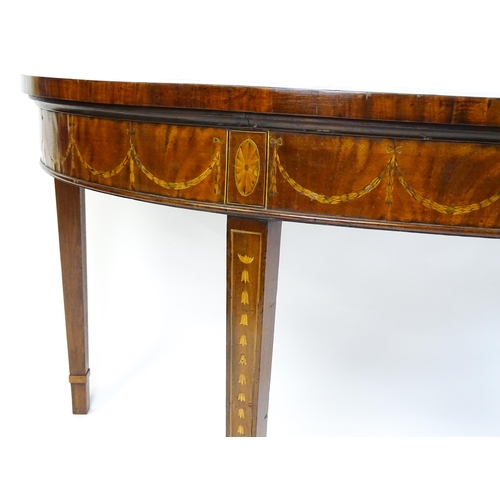 1573 - A large late 18thC mahogany serving table of demi lune form, having a marquetry inlaid top with sunb... 